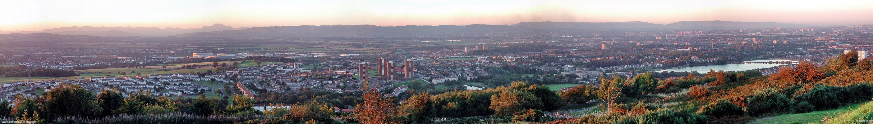 Gleniffer Braes evening sun panorama
The tower blocks of the Glasgow in the distance on the right are illuminated by the setting sun.  Taken in 2004 before the Foxbar flats were demolished.  The Distinctive outline of Ben Lomond can be left of centre.  [url=http://www.multimap.com/map/browse.cgi?lat=55.8143&lon=-4.4656&scale=25000&icon=x/]Map location[/url]
