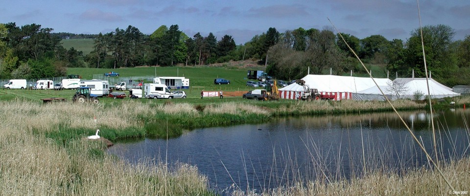 Preperations on eve of 2007 Neilston show at Holehouse
The nesting swan on the old mill pond seems unconcerned at all the activity taking place in the field behind as preperations are under way on the eve of the 2007 Neilston show.

