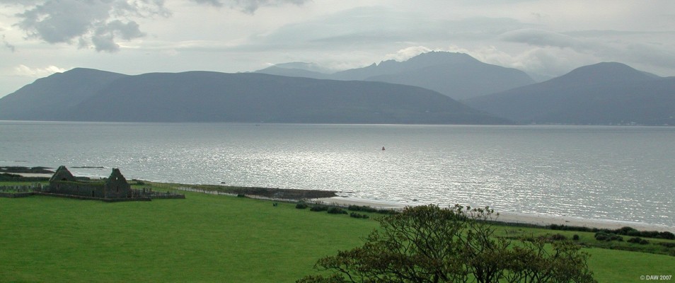 Arran from Skipness
For those familiar with the craggy outline of Arran from the Ayrshire coast this view seems like a completely different Island.  Taken from the top of Skipness Castle, on the left is the ruins of the 13th century Chapel.  The houses of Lochranza can be seen along the shore line on Arran on the right had side. [url=http://www.streetmap.co.uk/streetmap.dll?G2M?X=190850&Y=657785&A=Y&Z=5/]Map location[/url]
