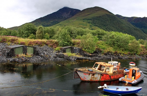 The old pier at Ballachulish
Sgorr Dhearg rises to some 1024 metres in the background.  The boat houses are made with local stone quarried in the hills around.  From 1693 until 1955 slate was quarried at Ballachulish. [url=http://www.streetmap.co.uk/map.srf?X=208196&Y=758637&A=Y&Z=115/] Map location. [/url]
