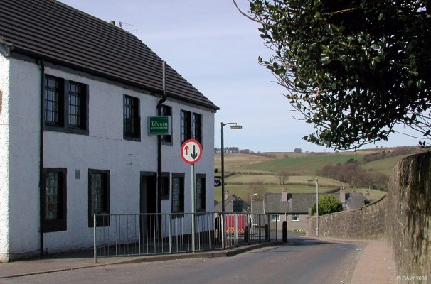 Looking down Broadlie Road from the Main Street
Taken in 2007, before The Tavern public house on the left caught fire and was demolished.  The Church graveyard is behind the stone wall on the right. [url=http://www.streetmap.co.uk/map.srf?X=247989&Y=657379&A=Y&Z=110/] Map location. [/url]
