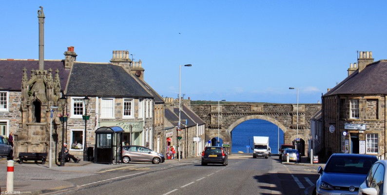 Seafield Street, Cullen
Looking down Seafield street in Cullen.  On the left is the Mercat Cross. The arched bridge carried the Great North of Scotland Railway along the Moray coast and was opened in 1886.  The line closed in 1968.  [url=http://streetmap.co.uk/map.srf?X=351313&Y=867073&A=Y&Z=110/] Map location. [/url]
