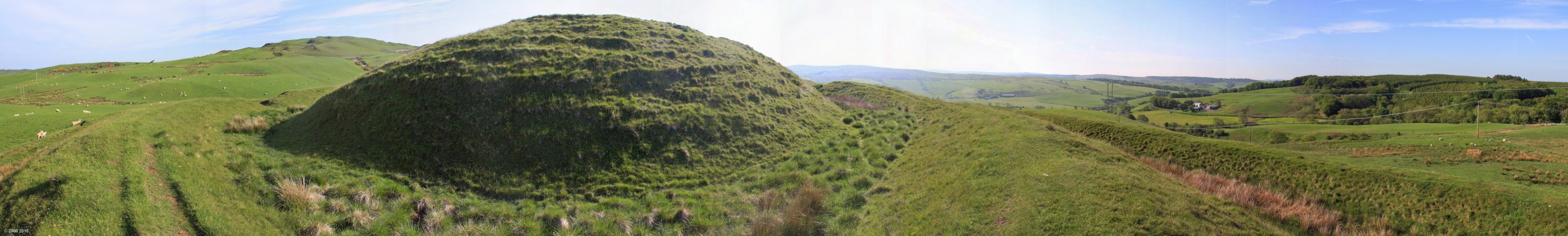 Dinvin Motte, near Girvan
Dinvin is an impressive earth structure dating from some 2,500 years ago.  The central mound is the Motte which is surrounded by two ring ditches best seen on the right hand side.  This photo is several joined together which has distorted the circular nature of the rings. [url=http://streetmap.co.uk/map.srf?X=219969&Y=593234&A=Y&Z=120/] Map location. [/url]
