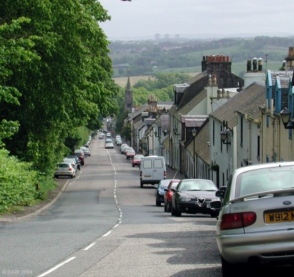 Eaglesham Village
A planned village dating from 1796.  It was built by the Earl of Eglinton for the workers of his cotton factory.  The spire of the Church built in 1790 is visible down the hill, in the distance the tower blocks of the modern planned town of East Kilbride can be seen.
