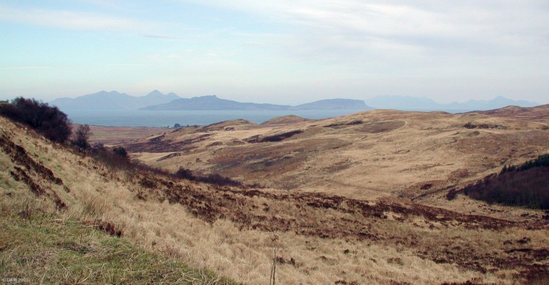The Islands of Eigg and Rhum as seen from Ardnamurchan
This early spring view still shows the winter colours on the Ardnamurchan Penninsula.  The island in the centre is Eigg, behind that to the left lies Rum.  Its highest peak is Askivel, rising to 812m.  On the right hand the peaks of the Cullin mountain range on the Isle of Skye can be seen in the distance.
