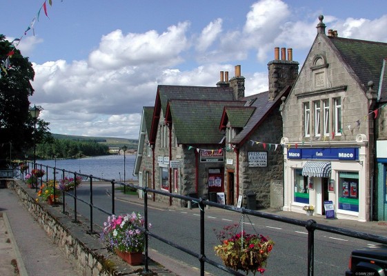 Main Street, Lairg, Sutherland
Said to be the gateway to Sutherland, Lairg developed in the early 19th century on the shores of Loch Shin.  The level of the loch was raised by some 11 metres after the opening in 1959 of the Lairg Hydro power station which can be seen in the distance.  [url=www.multimap.com/map/browse.cgi?lat=58.0237&lon=-4.4005&scale=5000&icon=x/]Map location[/url]
