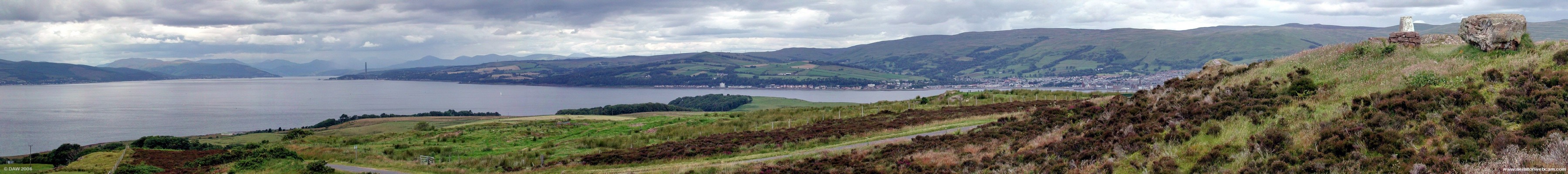 Looking up river from the Glaid stone, Great Cumbrae
The Glaid stone is on the extreme right of the picture, the white concrete block is the Ordnance Survey trig point.   The town of Largs can be seen on the right on the main land, moving left you see the 600ft Chimney at Inverkip power station (disused). The houses of Innellan, also on the mainland, can be seen on the left. [url=http://www.multimap.com/map/browse.cgi?lat=55.7725&lon=-4.9229&scale=25000&icon=x/]Map location[/url]
