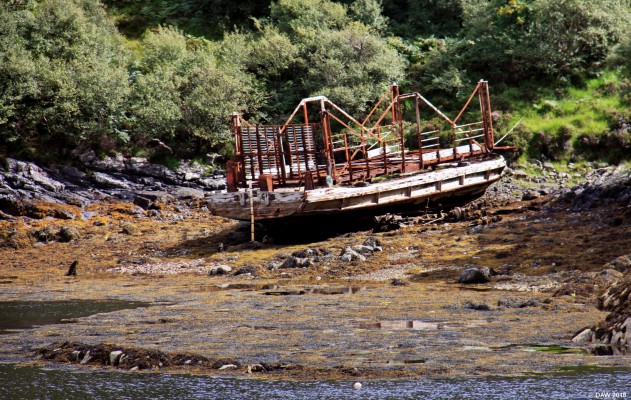 The Maid of Kylesku
When the old Kylestrome to Kylesku ferry was replaced in 1967 it was laid up on the shore not far from Kylesku and that is where it seems to have remained.  As you can see from its size it probably could only take about 4 cars.  The crossing remaining a bottleneck in the Journey up the west coast until the Kylesku bridge was opened in 1984. [url=http://www.streetmap.co.uk/map.srf?X=223055&Y=932959&A=Y&Z=115&ax=222958&ay=933542/] Map location. [/url]
