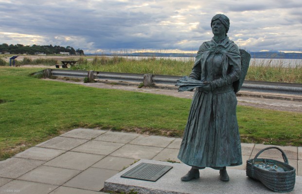 The Nairn Fishwife, Nairn Harbour
In the late 19th century the Fishwife played an important role in the community.  Apart from raising their own family, she would gather bait and also pine cones for smoking the fish.  Prepare and smoke the fish and then sell them in the local area.
