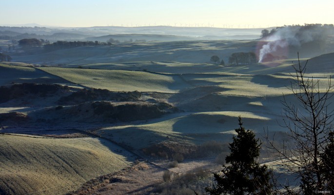 Looking east from the Neilston Pad
A frosty winter morning on top of the Neilston Pad.  The long shadows highlight how the features in the landscape all face the same way, the direction in which the ice flowed during the last ice age some 20,000 years ago.  In the top left hand corner you can make out what I suspect are the Pentland Hills over near Edinburgh.  [url=http://streetmap.co.uk/map?X=247660&Y=655249&A=Y&Z=120/] Map location. [/url]

