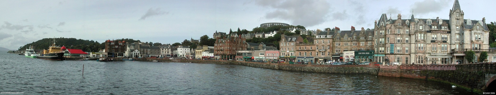 Oban sea front, 2006
A view from the ferry terminal along the sea front at Oban.  McCaig's Tower dominates the hill top.  [url=http://www.streetmap.co.uk/map.srf?X=185755&Y=729930&A=Y&Z=120/] Map location. [/url]
