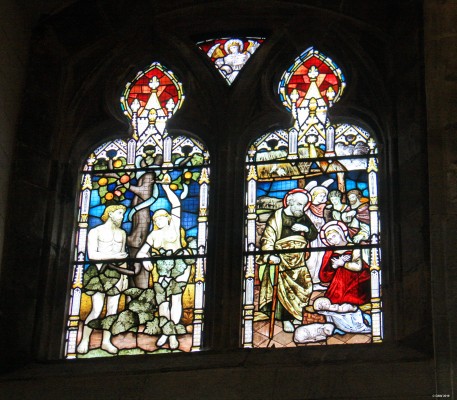Paisley Abbey stained glass Window 1
Stephen Adam's "Sin and Redemption" window. The fifth window, counting from East to West, in the South Aisle.  This is a memorial window donated by R.T.N. Speir in memory of his uncle Thomas Speir of Burnbrae, who died in 1874. The left light represents Adam and Eve being tempted; the right light the Holy Family, shepherds and angels behind, and a lamb (emblem of Christ) reclining beside the basket bed in which the infant Jesus lies. 
