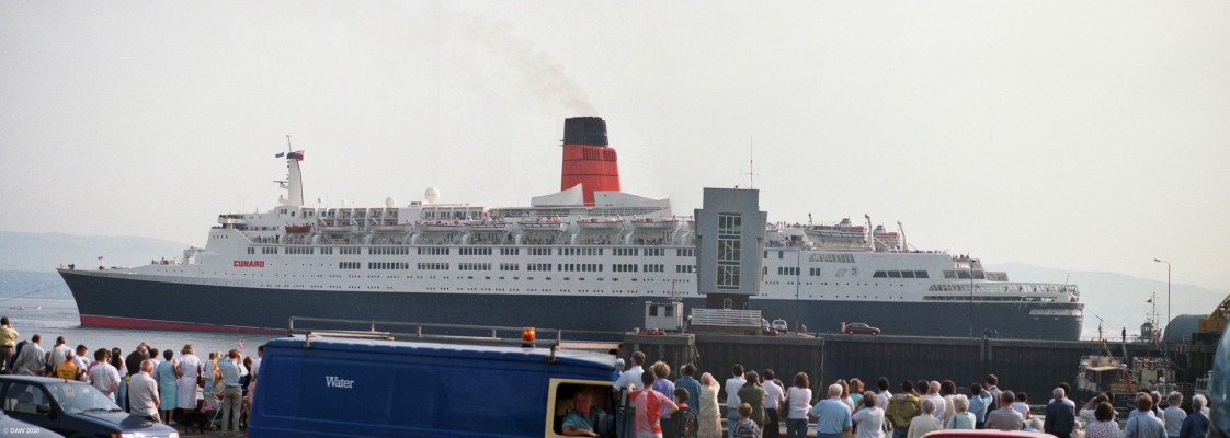 QE2, Greenock, 1990
The QE2 you see here was significantly different from that launched at Clydebank in 1967.  After continuing problems with the steam turbine Cunard decided in 1986 to give the QE2 a major refit during which the steam boilers and turbine were removed and replaced by desiel generators and electric propulsion.  New propellors were also fitted at the same time and considerable modernisation of passenger accomodation took place too at a cost of one hundred million pounds.  
