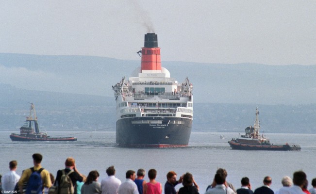 QE2, Greenock July 1990
The QE2 is turned off the esplanade at Greenock in preperation for docking at the Container Terminal.  One of the biggest changes in the ship since she was launched on the Clyde in 1967 is the funnel you see here.  When launched she had a narrower more streamlined funnel.

