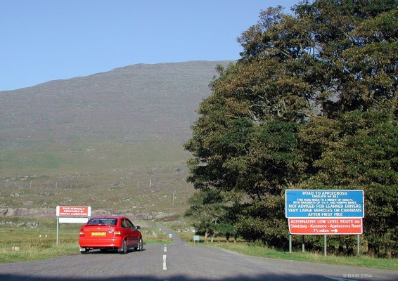 The road to Applecross, if you dare
These signs are what confronts the driver who chooses to take the high road to Applecross.  At 2053ft its not quite the highest public road in the British Isles (that honour goes to the A93 at Glenshee) but with its single track and passing places it certainly makes for an interesting drive.  It's worth it though because at the summit you get great views over to the Isle of Skye, provided there isn't a heat haze like there was on this day :-(
