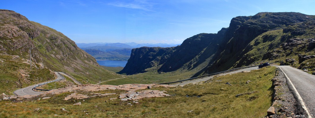Bealach na ba
Looking back from near the 2053ft summit of the old road to Applecross.  The road is single track with (small) passing places and steep drops with very shaky looking armco barriers.  This picture shows the road  corkscrewing back on its self  lower down.  Bealach na Ba means Pass of the Cattle, derived from its earlier use as a droving route for cattle. [url=http://www.multimap.com/map/browse.cgi?lat=57.4123&lon=-5.7024&scale=25000&icon=x/]Map location[/url]
