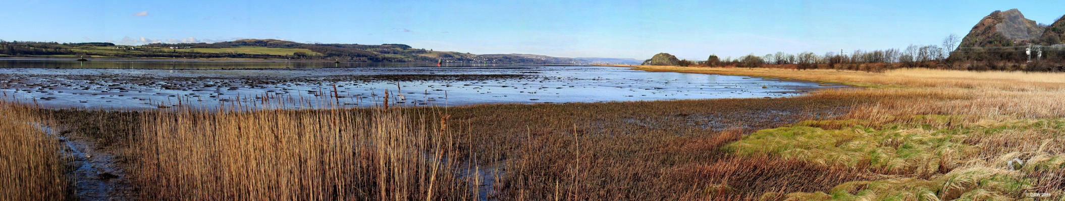 Dumbuck panorama, River Clyde
A view looking  west from the rather muddy foreshore of the Clyde at Dumbuck.  On the extreme right is the Dumbuck Quarry, right of centre is Dumbarton Rock and Castle, in the centre on the opposite bank in Langbank.  A Crannog was discovered on this muddy stretch of shore, it included a dock with intact log boat dating from around 200BC.
