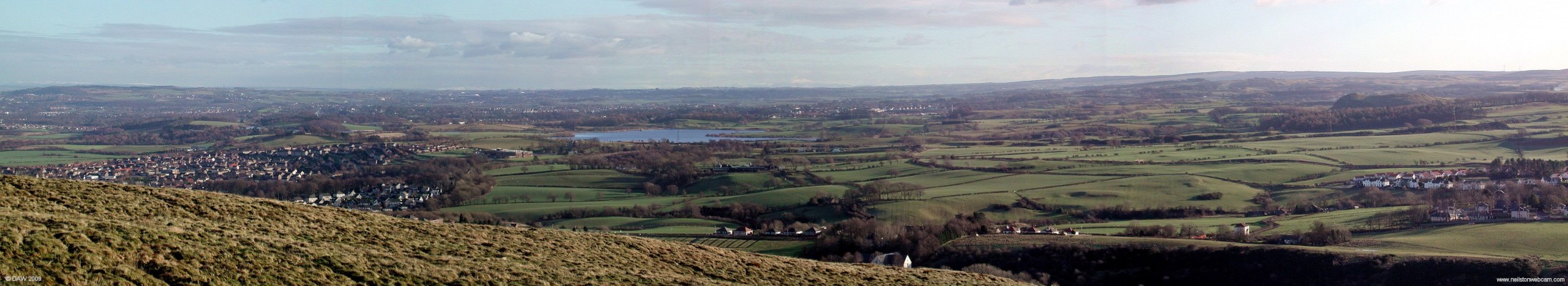 Panoramic view from top of Fereneze Hills, 2007
Looking east on a cold January afternoon from the top of the Fereneze Hills, the lower part of Neilston is on the right and the Auchenback area of Barrhead can be seen on the left.  If you look above the dams on the horizon you can just about make out the snow covered Pentland hills south of Edinburgh.  [url=http://www.streetmap.co.uk/map.srf?X=247790&Y=658590&A=Y&Z=120/] Map location. [/url]
