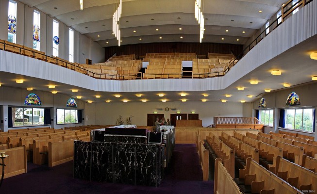 Inside Giffnock Synagogue
A view from the pulpit.  In Orthodox Judaism prayer is separated with the Ladies sitting upstairs and men downstairs.  The stained glass windows were commissioned by John Clark for Queens Park Synagogue which has since closed.  The raised platfrom is the 'Bimah' where the Rabbi or other competent lay reader leads the service from.
