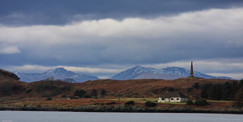 Looking over Kerrera to Mull
A view from Oban sea front looking towards the north end of the small Island of Kerrera with the mountains of Mull in the distance.  The monument is in memory of David Hutheson who was one of the founders of what today has become known as Caledonian Macbrayne ferries.  [url=http://www.streetmap.co.uk/map.srf?X=185497&Y=730634&A=Y&Z=120/] Map location. [/url]
