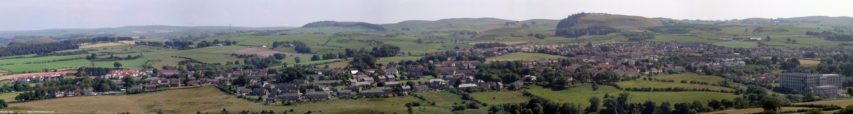 Panoramic view over looking Neilston from the Fereneze Hills
Taken in 2005 this view point shows how the village has developed over the years with the oldest part around the Church followed by the mill and the terraced houses above and all the later developments in between with the latest at the edges.  [url=http://www.streetmap.co.uk/streetmap.dll?G2M?X=247715&Y=658600&A=Y&Z=3/]Map location[/url]
