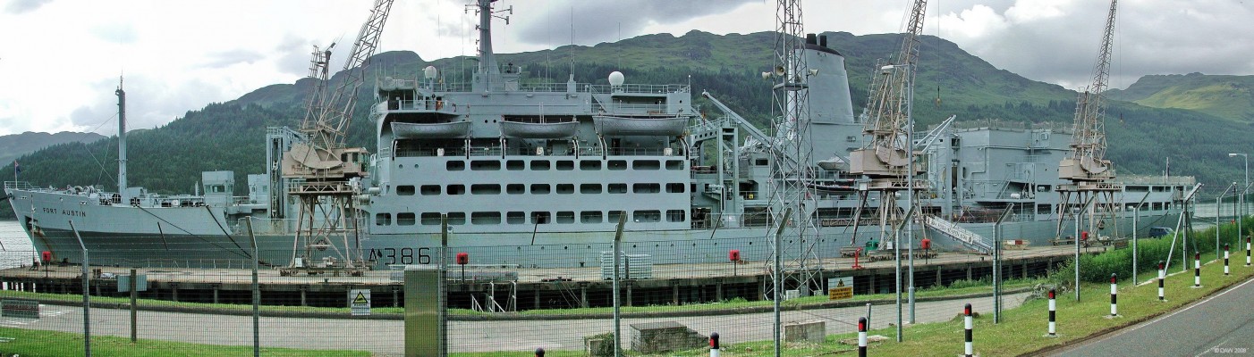 RFA Fort Austin at Glenmallan
Fort Austin berthed at the Glenmallan jetti.  I first started to take this photo through the gate but w advised by the gateman that, "the MOD don't like people doing that" and he kindly suggested I'd get a better view from car park on the other side of the road.  Taken in 2005, at 185m in length she doesn't quite fit the jetti.  In late 2007 she underwent a refit at Tyne & Wier.
