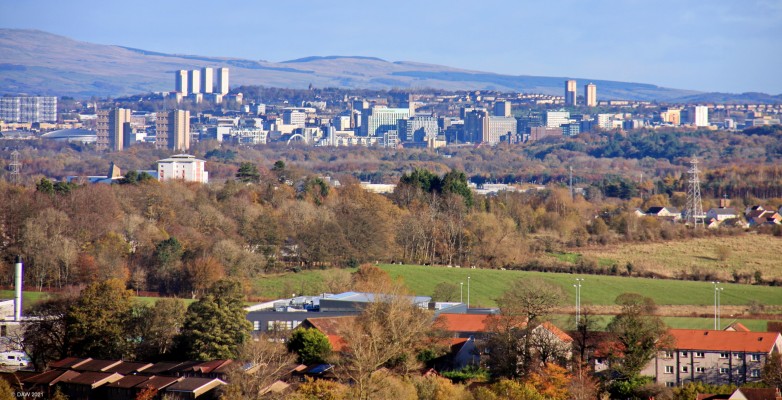 Glasgow from Barrhead
A view of Glasgow taken from the Springhill area of Barrhead.  The telephoto lens gives the impression that Glasgow is surrounded by trees but its really an illusion.Just left of centre you can see the Clyde Arc bridge which gives an idea where the river Clyde is running through the city centre.  Taken in late 2017 when the old (new) Barrhead High School was still standing, you can its boiler house chimmney on the left.
