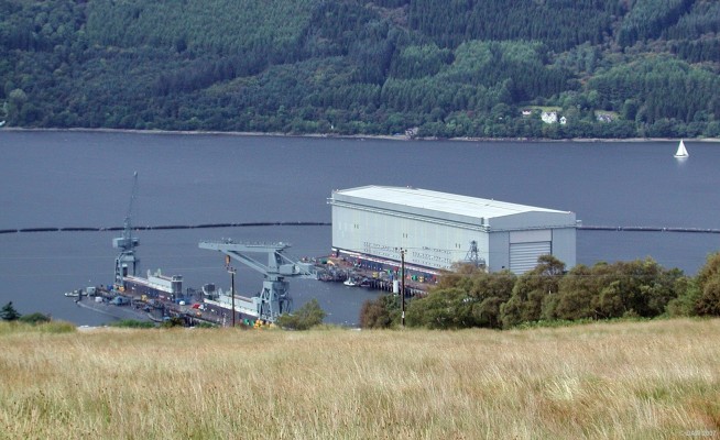 Trident Jetti and Shiplift seen from hills above
On the left you can see one of the Trident boats moored at the Jetti.  The Shiplift building on the right is capable of lifting a Vanguard class Trident submarine completely out the water for maintenance.  [url=http://www.multimap.com/map/browse.cgi?lat=56.0661&lon=-4.8066&scale=10000&icon=x/]Map location[/url]
